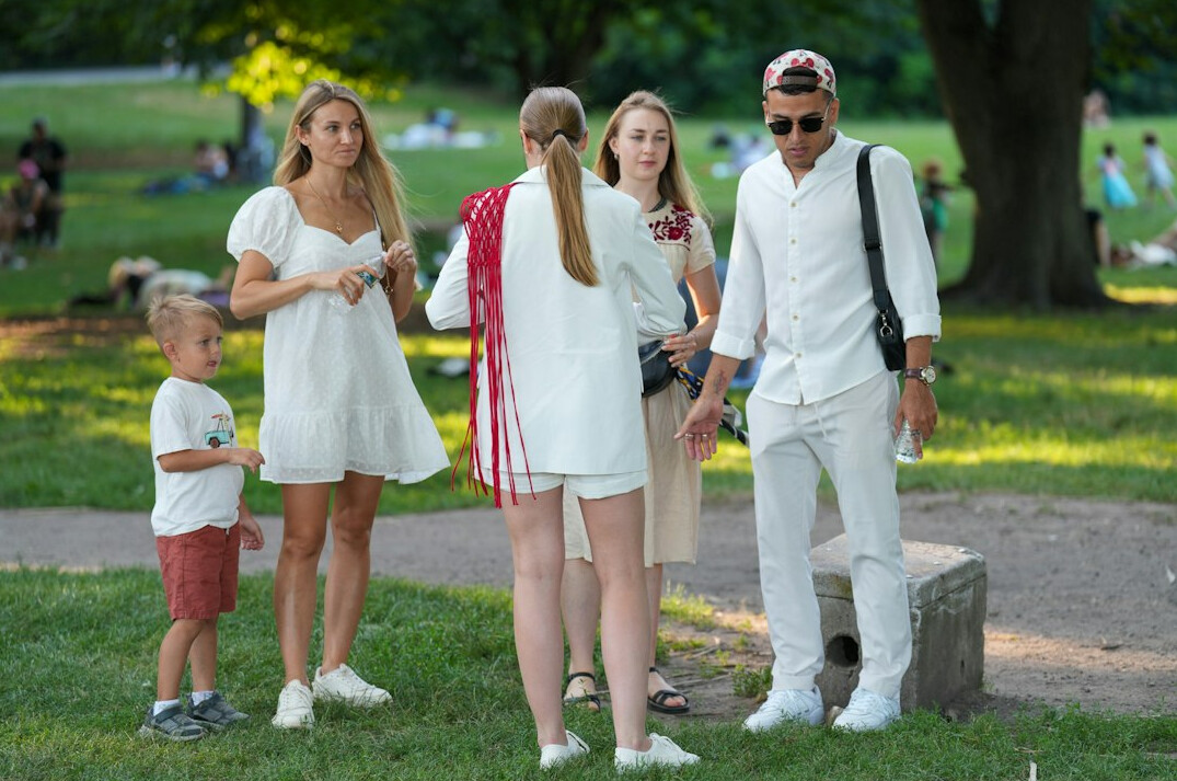 Happy family with two children walking in a green park